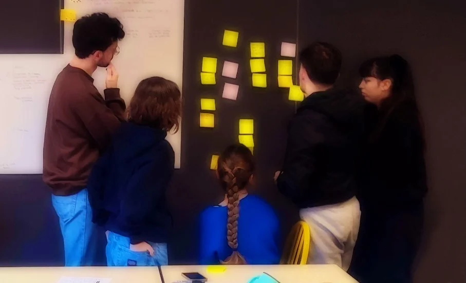 Cinq de mes étudiants en plein brainstorming avec des post-its
